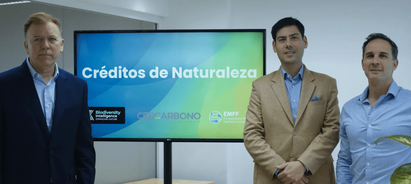 Patricio Lombardi (EMFF), Nahuel Schenone (BI) and Alex Saer (Cercarbono) beside the "Créditos de Naturaleza" screen at the Barcelona presentation.